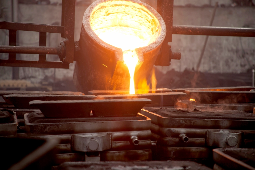 Smelting pot pouring liquid metal into a mold.